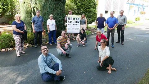 Vertreter*innen der Partnerschaften für Demokratie halten das Plakat der Kampagne